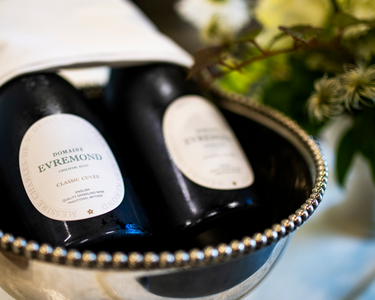 Close-up of Domaine Evremond Classic Cuvée bottles chilling in a silver wine cooler. The image highlights premium craftsmanship and English quality sparkling wine from Chilham, Kent. The setting suggests an elegant presentation suitable for tastings or private events.