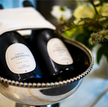 Close-up of Domaine Evremond Classic Cuvée bottles chilling in a silver wine cooler. The image highlights premium craftsmanship and English quality sparkling wine from Chilham, Kent. The setting suggests an elegant presentation suitable for tastings or private events.